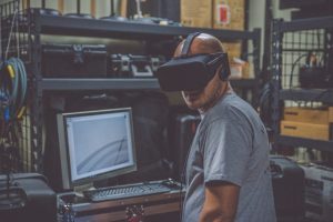 Man in VR headset in front of computer