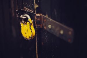 yellow padlock on rusty hinge 