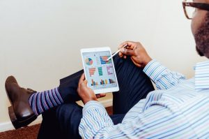 man using tablet looking at charts and graphs