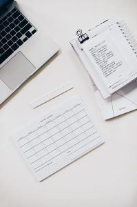 desk with notes, calendar and laptop