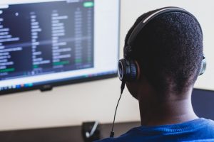 man at desk wearing headset working on computer