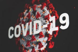 covid-19 virus model with white writing 
