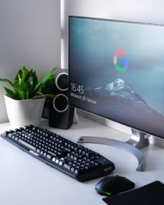 desk with monitor mouse keyboard and potted plant