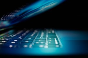 grey laptop half closed and glowing