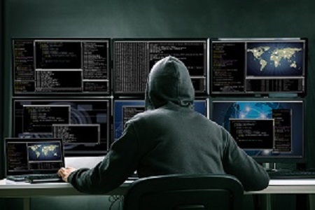cyber criminal sitting in front of desk